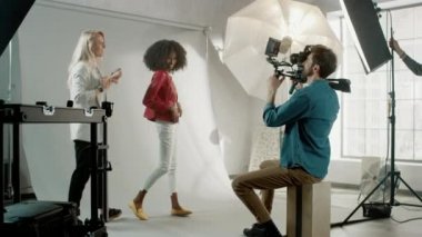 Video klip için güzel siyah model pozu, kameraman onu çekiyor. Yüz ifadeleri ile oynuyor. Şık Moda Dergisi. Fotoğraf çekimi Stüdyoda Pro Ekipman ile yapılır