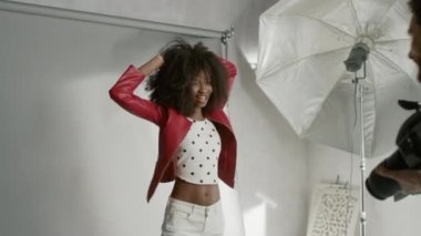 Bir fotoğrafçı için güzel siyah model pozu, Profesyonel Kamerayla Fotoğraf Çekiyor. Yüz ifadeleri ile oynuyor. Moda Dergisi Fotoğraf Çekimi Bir Stüdyoda Profesyonel Malzeme ile Yapıldı