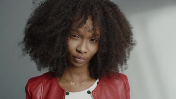 Ελκυστικό μαύρο κορίτσι με βελούδινα σγουρά μαλλιά Posing για ένα περιοδικό μόδας Photoshoot. Beautiful Girl Smiles Playfully, Πράξεις και έργα με εκφράσεις προσώπου. Φωτογράφηση σε επαγγελματικό στούντιο — Αρχείο Βίντεο