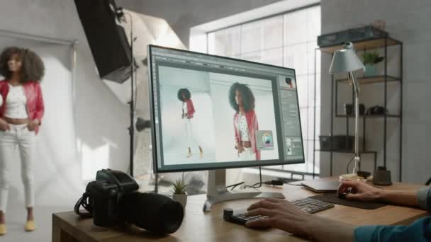 プロの写真家彼の机に座っていると、写真スタジオのレタッチでデスクトップコンピュータを使用します。写真撮影後、彼は画像編集ソフトウェアで美しい黒の女性モデルの写真をリーチ — ストック動画