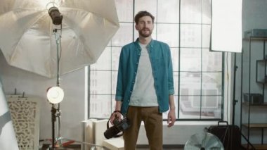 Profesyonel Ekipmanlı Fotoğraf Stüdyosunda: Yakışıklı Fotoğrafçı Holding State of the Art Camera Arka planda Softbox Aydınlatma ile Fotoğraf Çekmeye Hazır