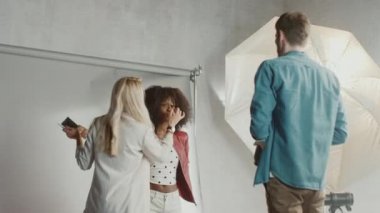 Fotoğraf çekiminin kulisinde: Makyöz, Güzel Siyah Modele Makyaj Uygular, Profesyonel Kamerayla Fotoğraf Çekmeye Başlar. Moda Dergisi Stüdyo Fotoğrafları