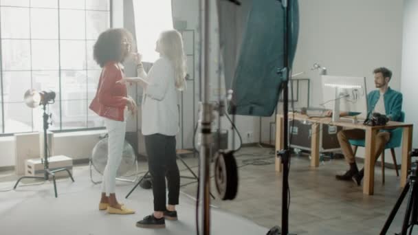 Backstage of the Photoshoot: Make-up Artist Applies Makeup on Beautiful Black Girl. Photo Editor Works on Desktop Computer Retouching Photo with Image Editing Software. Fashion Internet Magazine — Stock Video