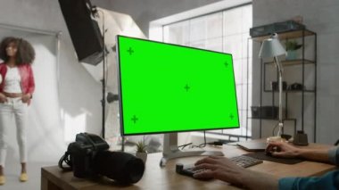 Makyaj Sanatçısı Güzel Siyah Kız 'a Makyaj Yapıyor. Green Mock-up Screen Ekranı ile Masaüstü Bilgisayarında Fotoğraf Düzenleyici Çalışıyor. Moda İnternet Dergisi