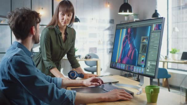 Female Art Director Consults Designer Colleague, They Work on a Portrait in Photo Editing Software (dalam bahasa Inggris). Mereka bekerja di Cool Office Loft. Mereka tampak sangat kreatif dan keren. — Stok Video