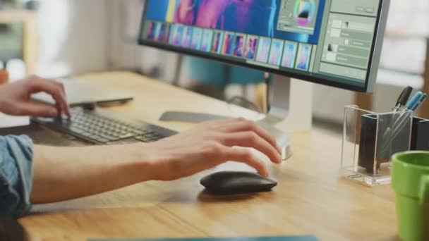 Närbild skott av Designers händer som arbetar i bildredigering programvara på hans persondator med stor skärm. Han jobbar på Cool Office Loft. Tablet och hörlurar Ligg på bordet. — Stockvideo