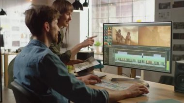 Güzel Kadın Sanat Yönetmeni Yakışıklı Video Editörü Meslektaşı Astronotlar hakkında bir video projesi üzerinde çalışıyorlar. Havalı bir ofiste çalışıyorlar. Çok yaratıcı ve havalı görünüyorlar..