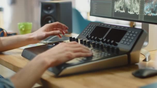 Close Up Shot of Video Editors Hands Working with Footage on His Personal Computer Using an Editing Console Deck. He Works in Cool Office Loft. Laptop and Headphones Lie on the Table. — Stock Video