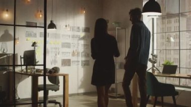Genç Yaratıcı Erkek ve Kadın Havalı Ofislerinin Duvarında Bir Ruh hali kurulu düzenliyor. Resimler Gelecek Hareketi Videosunu Sunar. Meslektaşlar Proje 'yi tartışıyor. Güneşli Gün.