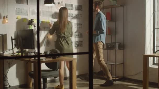 Unga kreativa män och kvinnor organiserar en Storyboard på en vägg av deras Cool Office Loft. Bilder Representera Framtida Rörelse Video. Kollegerna arbetar och diskuterar projektet. Solig dag. — Stockvideo