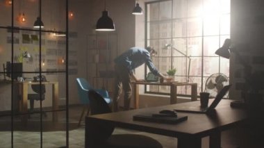 Yaratıcı Geliştirici Stüdyosunda Dizüstü bilgisayarda çalışıyor. Sunny Loft Ofisinde Uygulamalar ve Sosyal Medya Tasarım Yapısı Tasarımı. Kağıda Notlar Yazar ve Pencereden Modern Şehir Manzarasına Bakar.