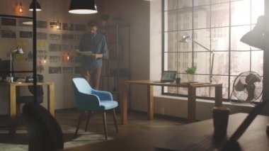 Yaratıcı Geliştirici Stüdyosundaki Storyboard 'da çalışıyor. Sunny Loft ofisindeki dizüstü bilgisayarında Sosyal Uygulamalar Tasarımı tasarımı. Kağıda Notlar Yazar ve Pencereden Modern Şehir Manzarasına Bakar.