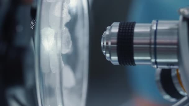 Verticale beeldmateriaal wetenschapper mengen van chemische stoffen onder microscoop — Stockvideo