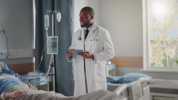 Врач отделения больницы беседует с пациентом в постели — стоковое видео