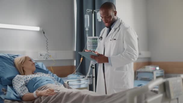 Médico de la sala del hospital habla con paciente en cama — Vídeos de Stock