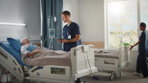 Hastane koğuşu doktoru yaşlı hastayla yatakta konuşuyor. — Stok video