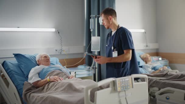 Médico de la sala del hospital habla con viejo paciente en la cama — Vídeos de Stock