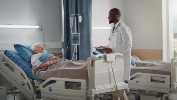 Il medico del reparto ospedaliero controlla il vecchio paziente a letto — Video Stock