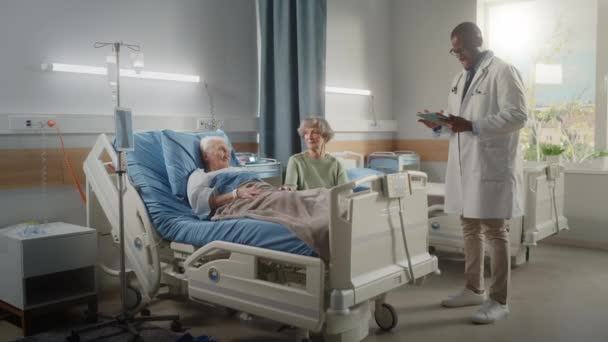 Hospital Ward Old Husband en la cama habla con su esposa visitando al doctor habla — Vídeo de stock