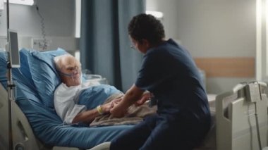 Hastane koğuşundaki yaşlı adam yatakta oksijen maskesi takıyor.