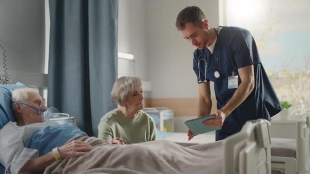 Старый муж в палате больницы разговаривает с женой в постели — стоковое видео
