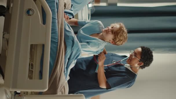 Vertical Screen Hospital Ward Young boy in Bed Nurse Does Checkup — Stock Video