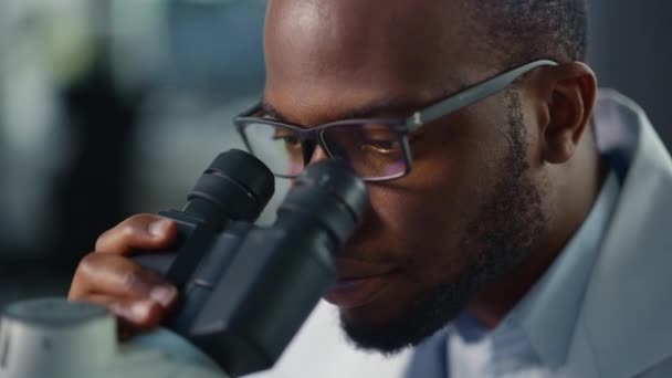 Macro Beeld Zwarte Mannelijke Wetenschapper die Microscoop in Laboratorium gebruiken — Stockvideo