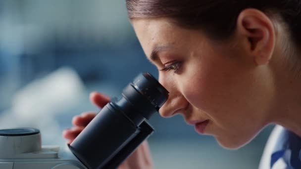 Macro metraggio scienziata femminile utilizzando il microscopio in laboratorio — Video Stock