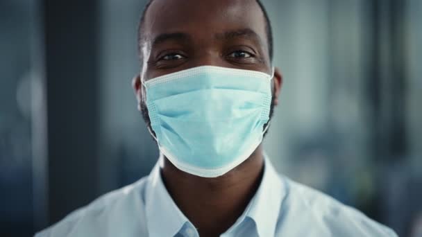 Крупним планом портрет чорний чоловік лікар в масці для обличчя — стокове відео