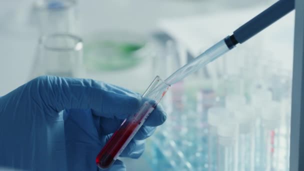 Forskare som blandar kemikalier enligt mikroskop — Stockvideo