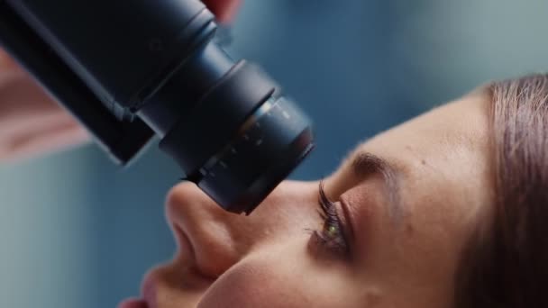 실험실에서 현미경을 사용하는 수직적 인보 금자리의 암컷 과학자 — 비디오