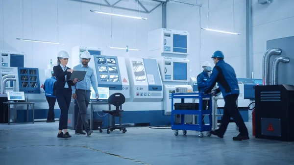 Ingénieur en chef et gestionnaire de projet masculin Promenade dans l'usine moderne, parler et planifier Optimisation de la production. Installation industrielle : Professionnels travaillant sur des machines CNC, bras de robot — Photo