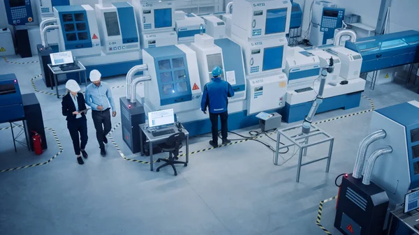 Industria Cuatro Fábrica: Taller de la instalación de inspección del ingeniero ejecutivo y jefe femenino, mire el brazo del robot que trabaja en la línea de montaje. Maquinaria y equipo CNC de gama alta. Ángulo alto — Foto de Stock