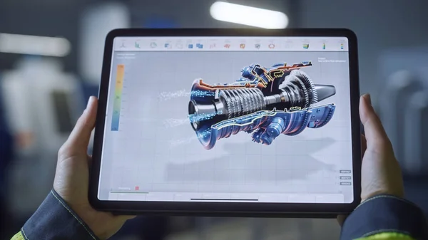 Industria 4.0 Fábrica: Ingeniero Jefe y Supervisor de Proyectos sostiene Tablet Computer Digital. La pantalla muestra el concepto 3D del nuevo motor a reacción. Taller con maquinaria tecnológicamente avanzada. — Foto de Stock
