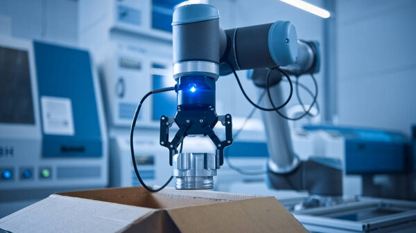 Industry 4.0 Modern Factory: Programmed Robot arm Packing Metal Components into Cardboard Box. Production Line Machine Picks Packs Product into Package on Conveyor. Fully Automated Warehouse Robotics — Stock Photo, Image