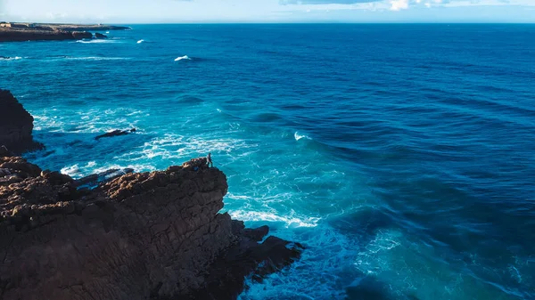 Aerial Drone Shot: Portugalski Rocky Shore z pięknym widokiem na ocean. Latanie nad Portugalią, linia brzegowa z Oceanic Waves Rolling, zderzając się z klifami. Samotny rybak wędkuje. Praia do Guincho — Zdjęcie stockowe