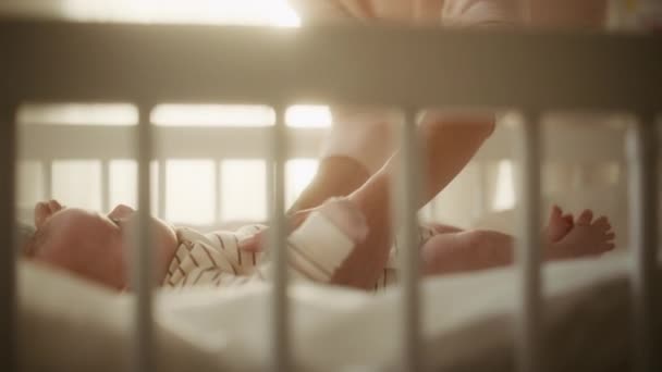 Madre recoge al bebé recién nacido de la cuna — Vídeos de Stock