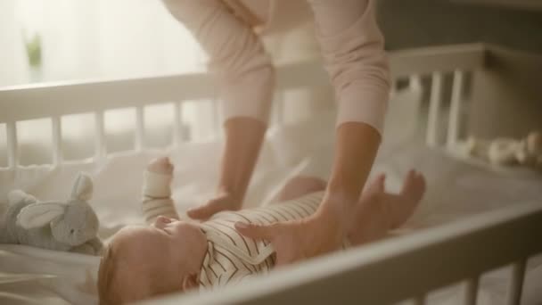 Mamma plockar upp det nyfödda barnet från barnsäng — Stockvideo