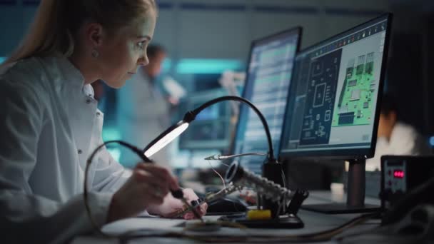 Instalación de desarrollo de electrónica Female Scientist Soldering Motherboard — Vídeos de Stock