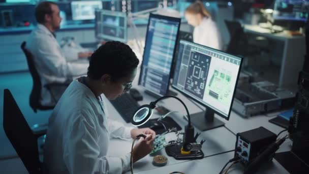 Instalación de desarrollo de electrónica Female Scientist Soldering Motherboard — Vídeos de Stock