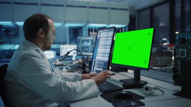 Ηλεκτρονικός επιστήμονας εγκατάστασης ανάπτυξης που εργάζονται σε πράσινη οθόνη υπολογιστή — Αρχείο Βίντεο