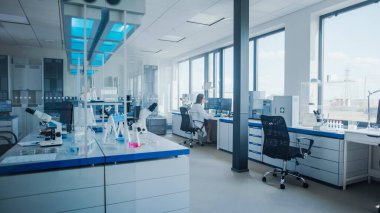 Uzak Köşe Masası 'nda çalışan kadın bilim adamıyla Modern Tıbbi Araştırma Laboratuvarı. Uyuşturucu ve Aşı Geliştirme Teknolojisi ile Bilim Laboratuvarı, Yüksek Teknolojik Ekipmanlarla Dolu