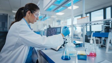 Modern Tıbbi Araştırma Laboratuvarı: Mikro Pipette ile çalışan Kadın Bilimadamı, Biyokimya Örnekleri Analizi. Gelişmiş Tıp, Mikrobiyoloji Geliştirme Laboratuvarı.