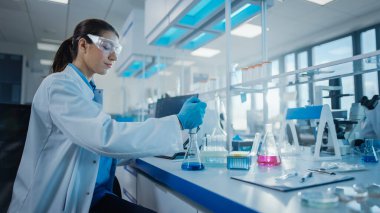 Modern Tıbbi Araştırma Laboratuvarı: Mikro Pipette ile çalışan Kadın Bilimadamı, Biyokimya Örnekleri Analizi. Gelişmiş Tıp, Mikrobiyoloji Geliştirme Laboratuvarı.