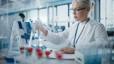 Tıbbi Araştırma Laboratuvarı: Gözlüklü Güzel Kadın Bilimadamının Test Analizi için Mikro Pipette Kullanması. Gelişmiş Tıp, Biyoteknoloji, Mikrobiyoloji Geliştirme Laboratuvarı