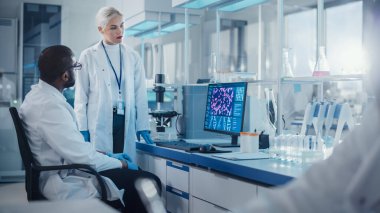 Modern Tıbbi Araştırma Laboratuvarı: İki Bilimadamı DNA Analizi Gösteren Bilgisayar Kullanıyor, Uzmanlar Yenilikçi Teknolojiyi Tartışıyor. Tıp ve Biyoteknoloji için Gelişmiş Bilimsel Laboratuvar