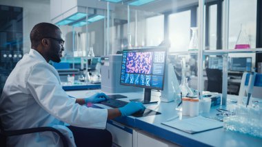 Modern Tıp Laboratuvarı: Erkek Bilimadamı, Klavyede Bilgisayar üzerine Yazıyor, Scren DNA Araştırma Kavramını Gösteriyor. Gelişmiş Bilimsel Laboratuvar, Tıp Biyoteknoloji Geliştirme.