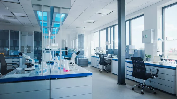 Modern medisch onderzoekslaboratorium met computer, microscoop, glaswerk met biochemicaliën op het bureau. Wetenschappelijk Lab Biotechnologie Development Center Vol met high-tech apparatuur. — Stockfoto