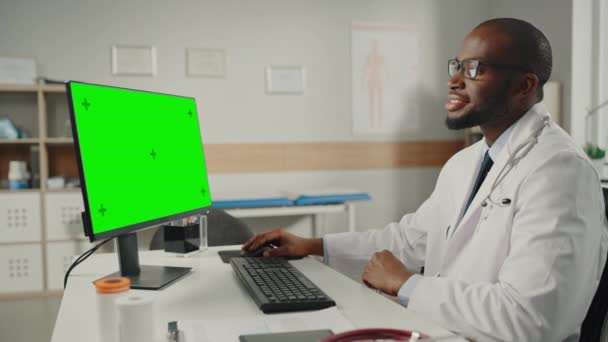 Médecin au bureau utilise un ordinateur avec écran vert — Video