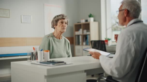 Врач говорит с пожилым пациентом — стоковое видео